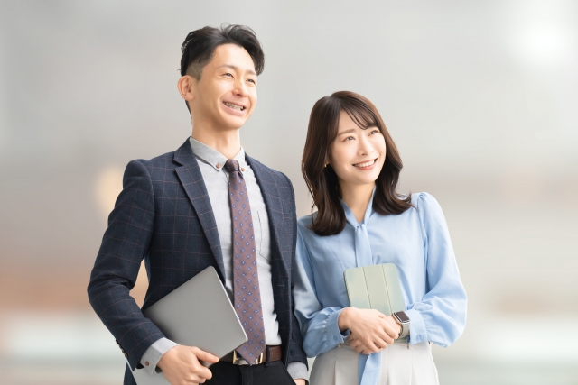 住宅模型を使って説明をする作業着の女性