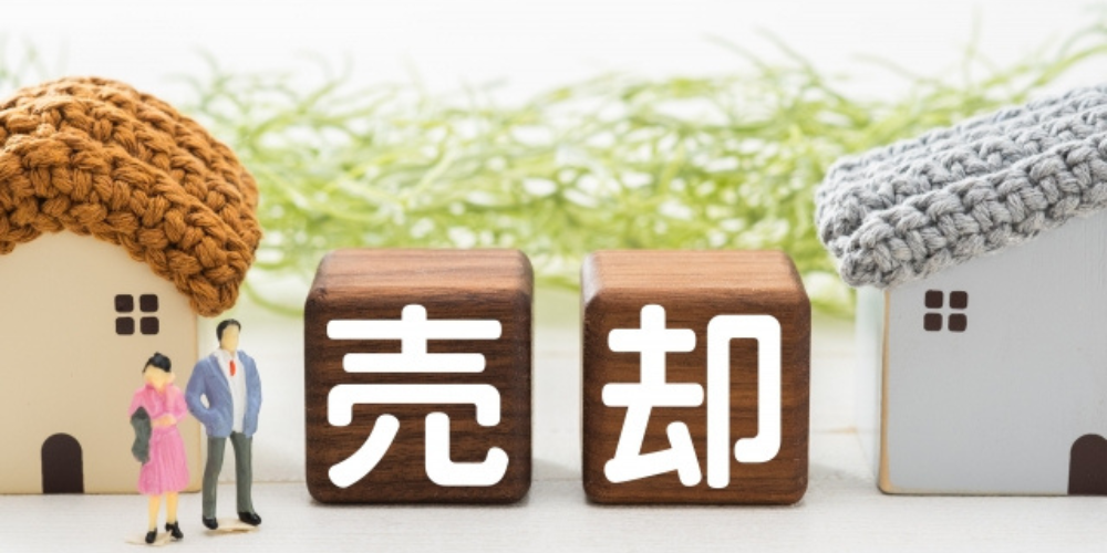 住宅売却を示す木製ブロックと家の模型