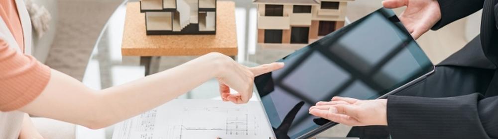 住宅模型と設計図を見ながらタブレットで相談する様子
