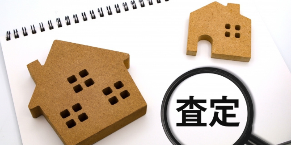 木製住宅模型と査定を示す虫眼鏡